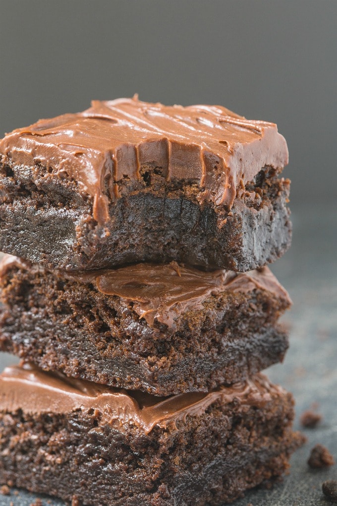 A close up shot of flourless fudge brownies with a healthy, thick frosting