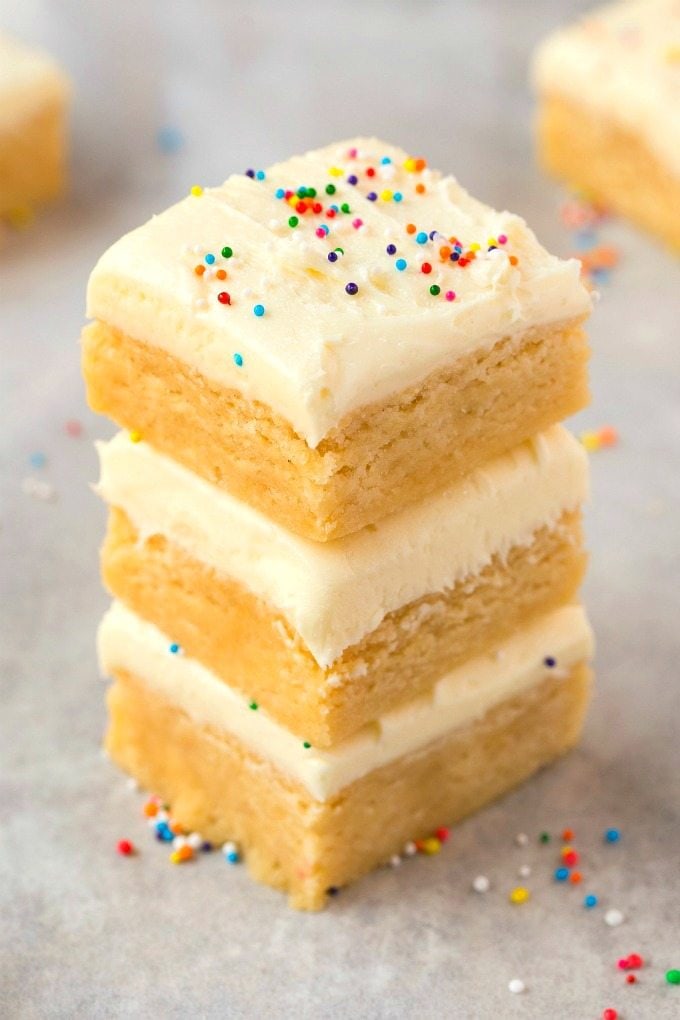 A stack of healthy no bake sugar cookie bars topped with a cream cheese dairy free frosting.