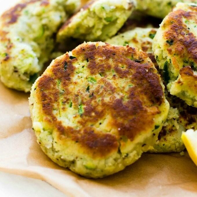 A plate of zucchini cauliflower fritters laying on a plate