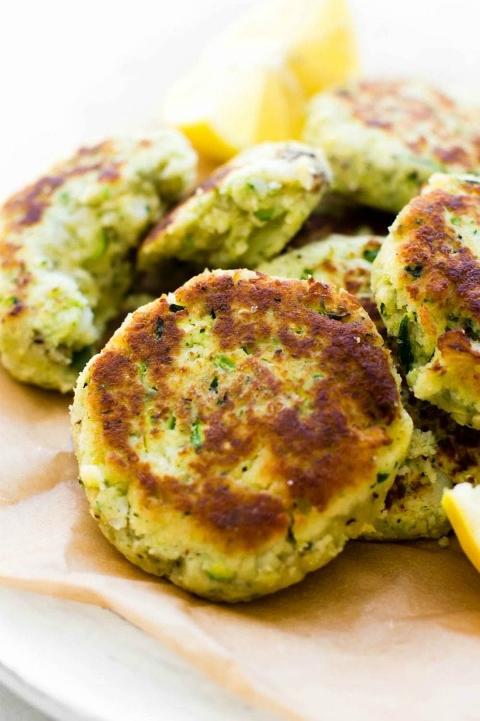A plate of zucchini cauliflower fritters laying on a plate