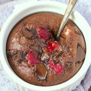 A single serving chocolate raspberry cake filled with raspberries and chocolate chunks.