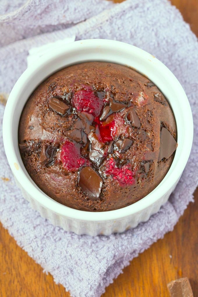 A chocolate raspberry keto mug cake loaded with chocolate chunks and fresh raspberries