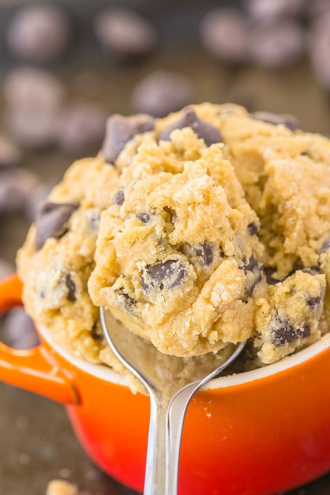 A spoonful of edible eggless cookie dough in a bowl topped with chocolate chips