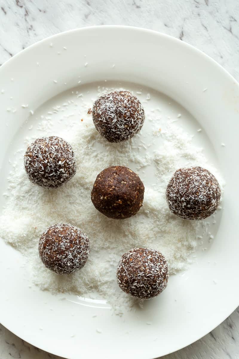 chocolate coconut bliss balls on shredded coconut