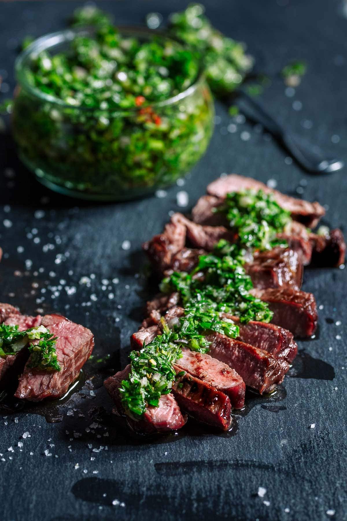 flank steak with chimichurri sauce on top. 