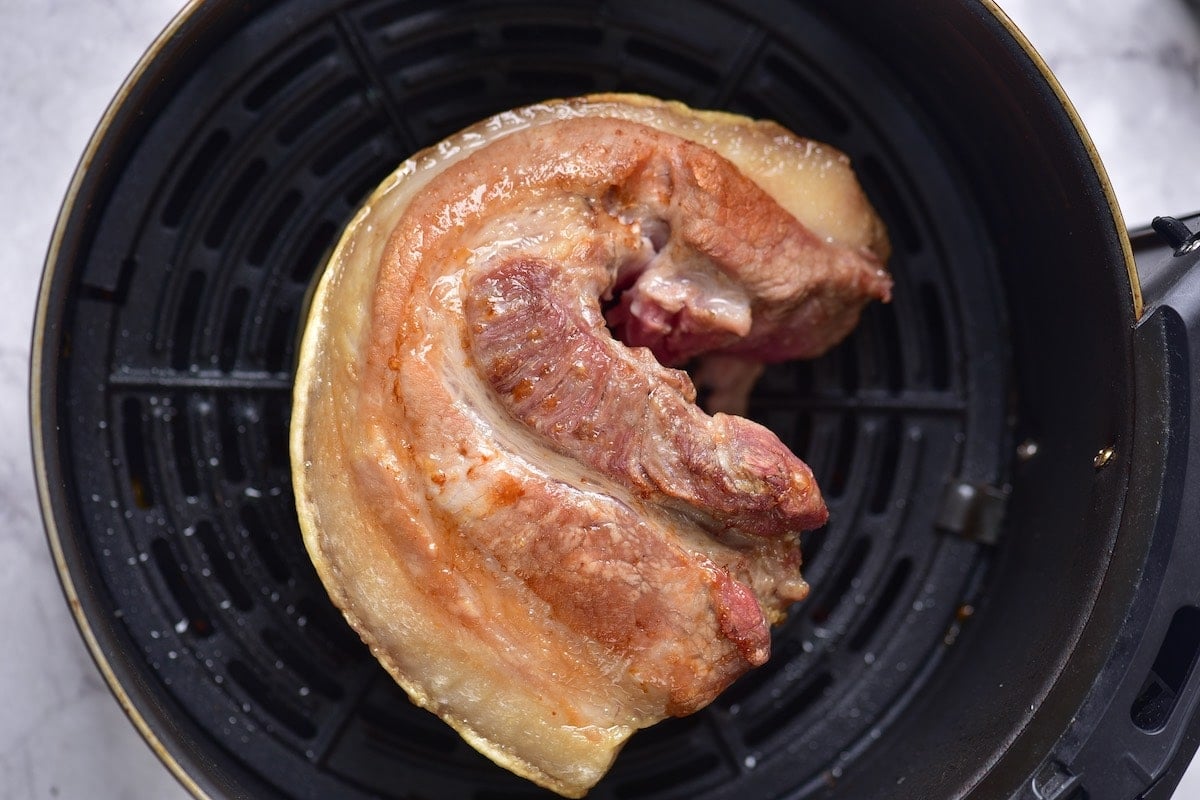 fried pork in air fryer basket.