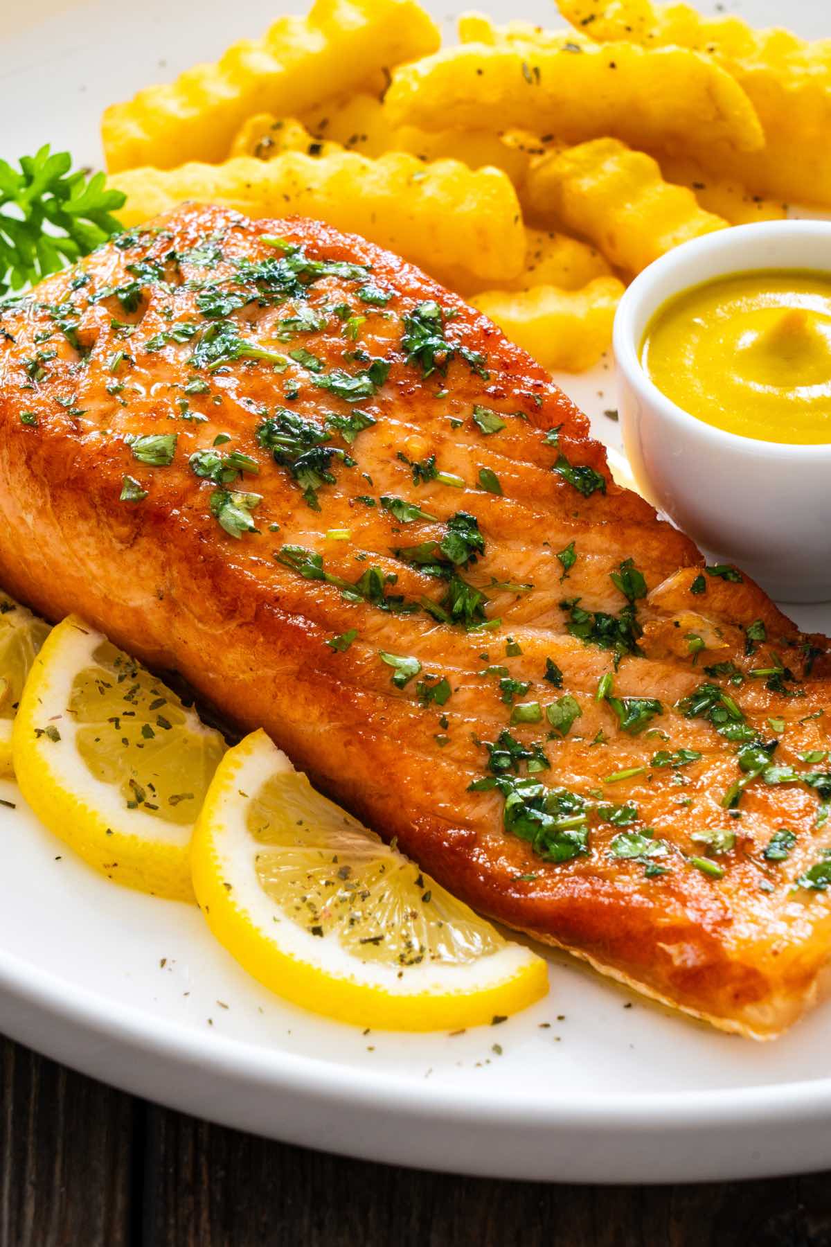 air fried salmon with herbs on top and fresh lemon slices.