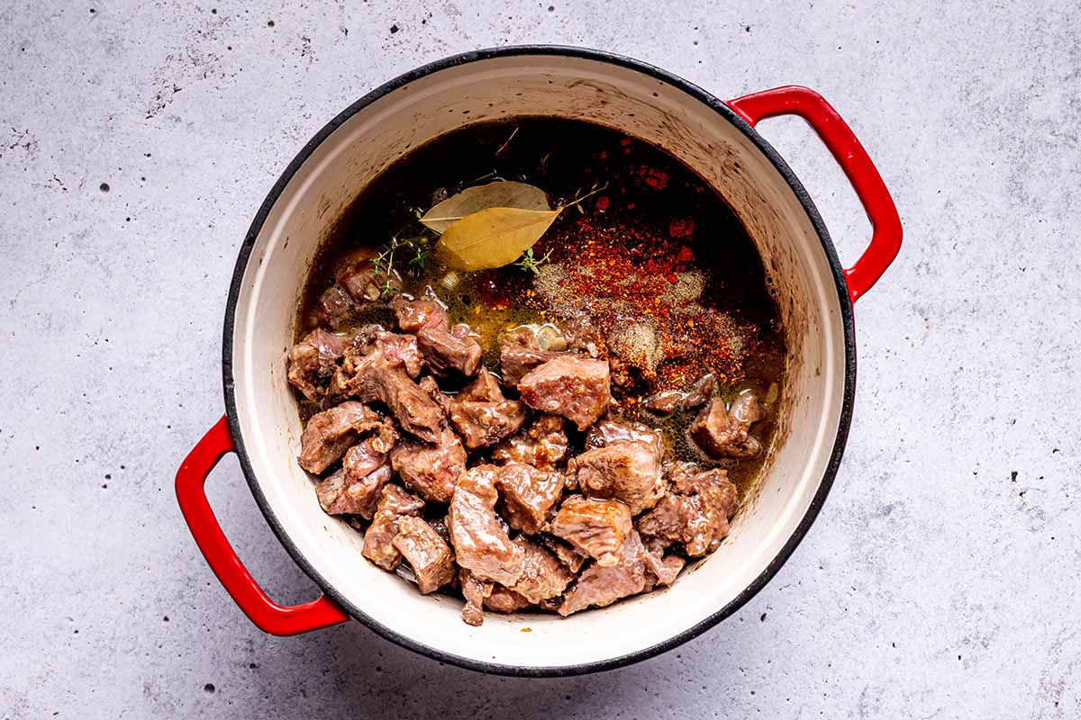 braised beef and stock in pot.