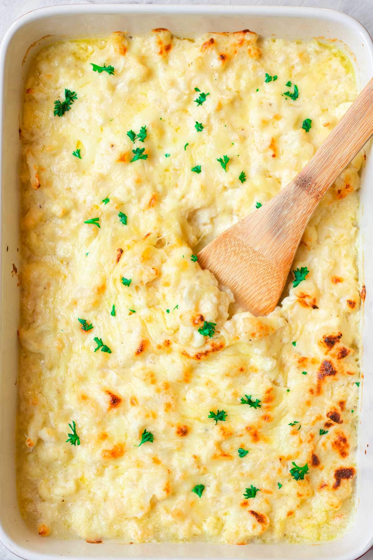 cauliflower mac and cheese in a white baking dish.