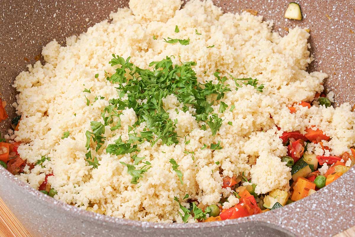 couscous added to veggies in pot.