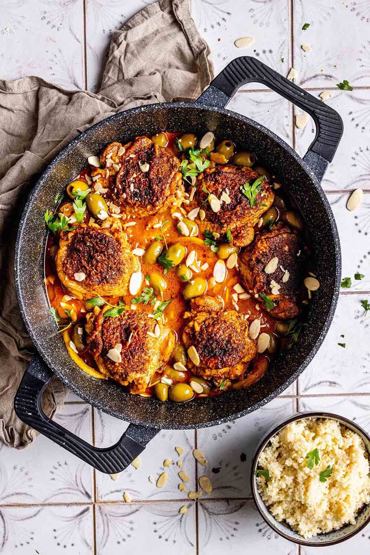 moroccan chicken in a skillet with fresh herbs.