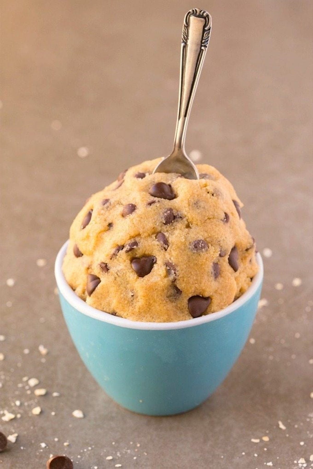 oatmeal cookie dough in a blue mug with a spoon.