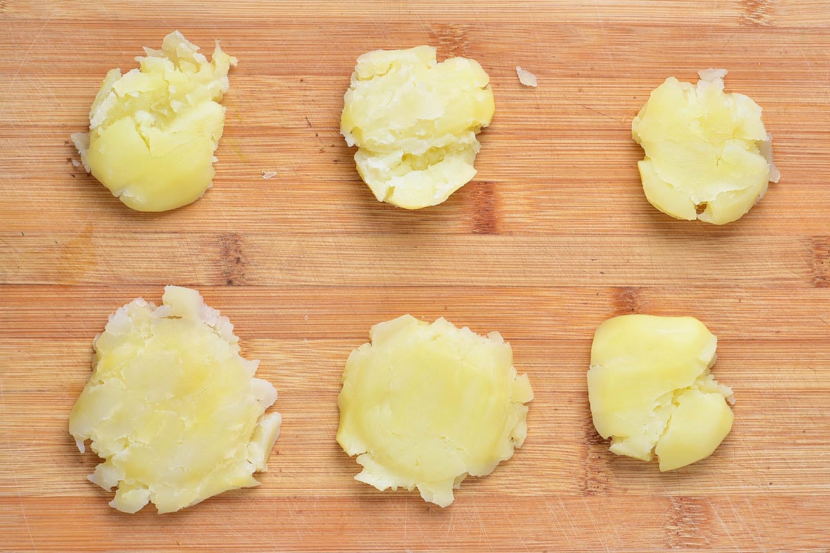 potatoes smashed on a board.