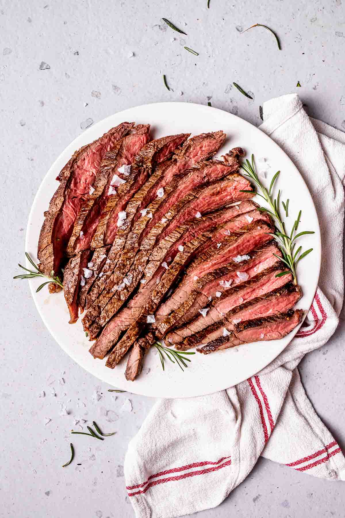 round steak on a plate with fresh herbs.
