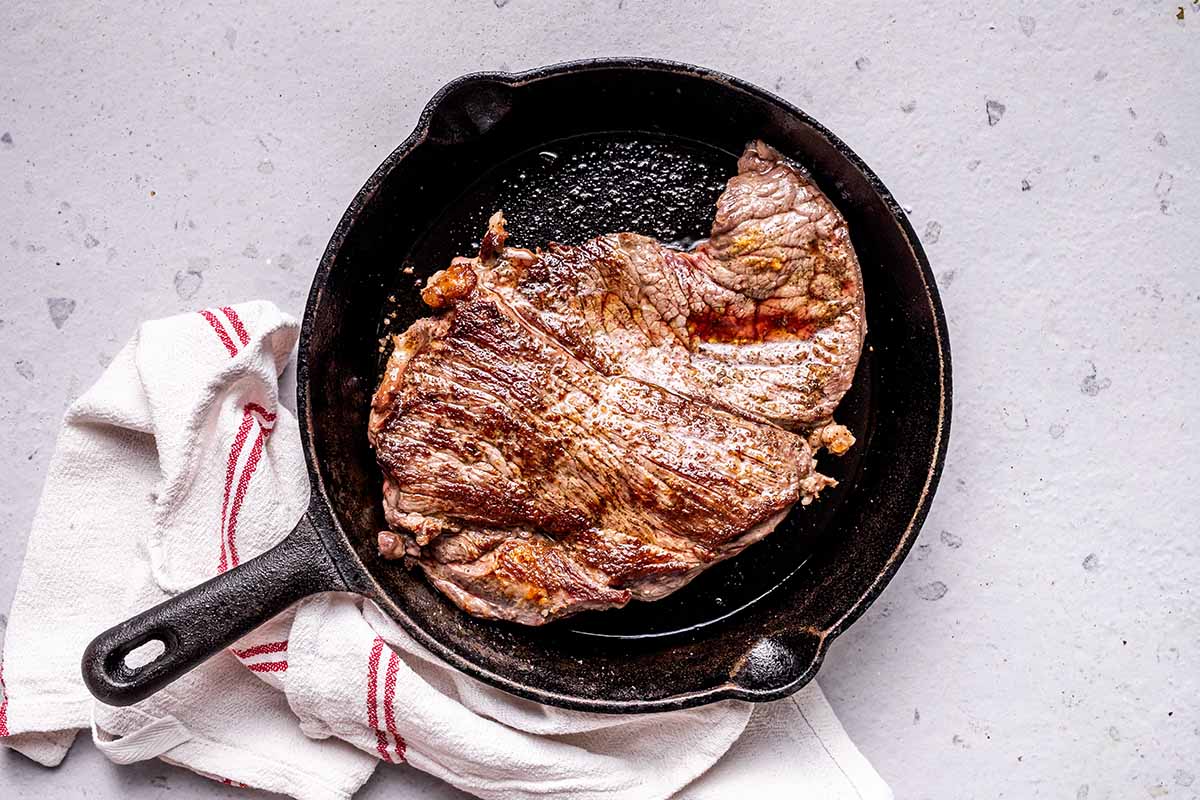 seared round steak in a skillet.