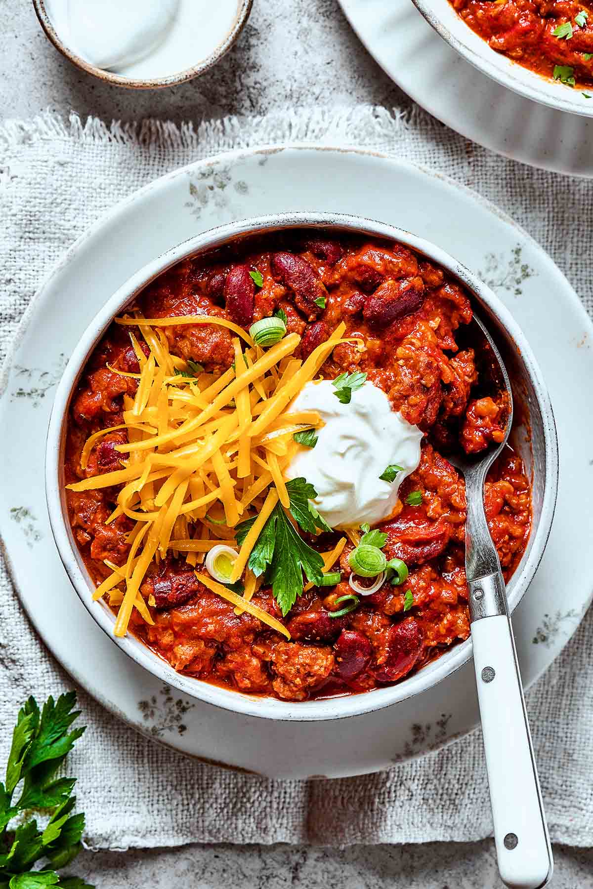 venison chili with sour cream, shredded cheese, and cilantro.