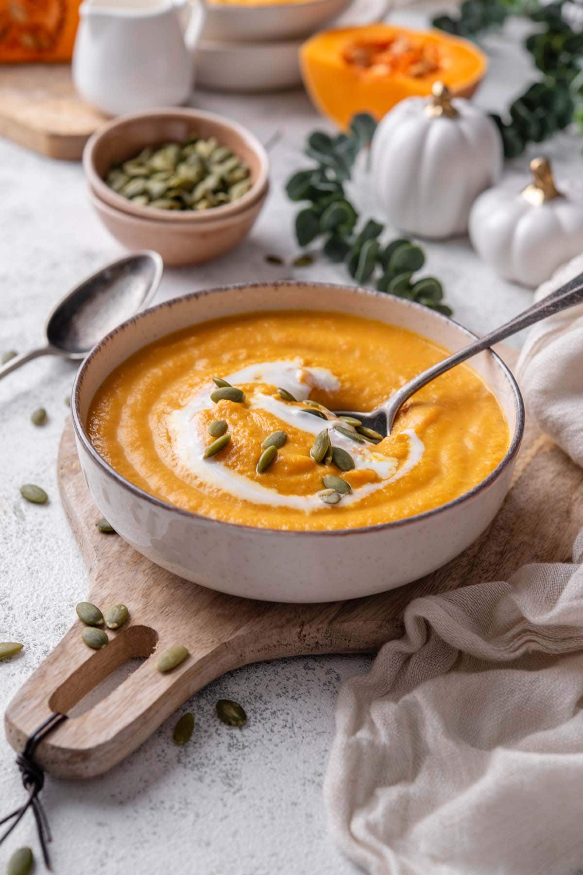 buttercup squash soup in a bowl with pumpkin seeds on top.