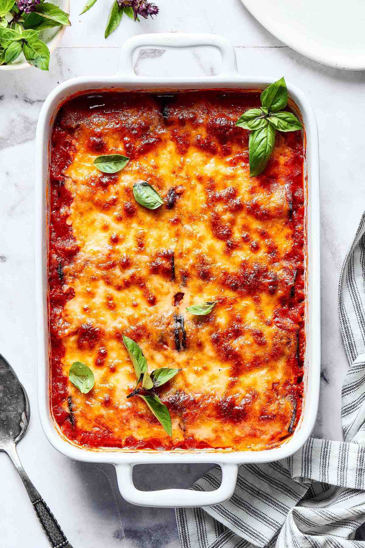 eggplant rollatini in a white baking dish with basil.