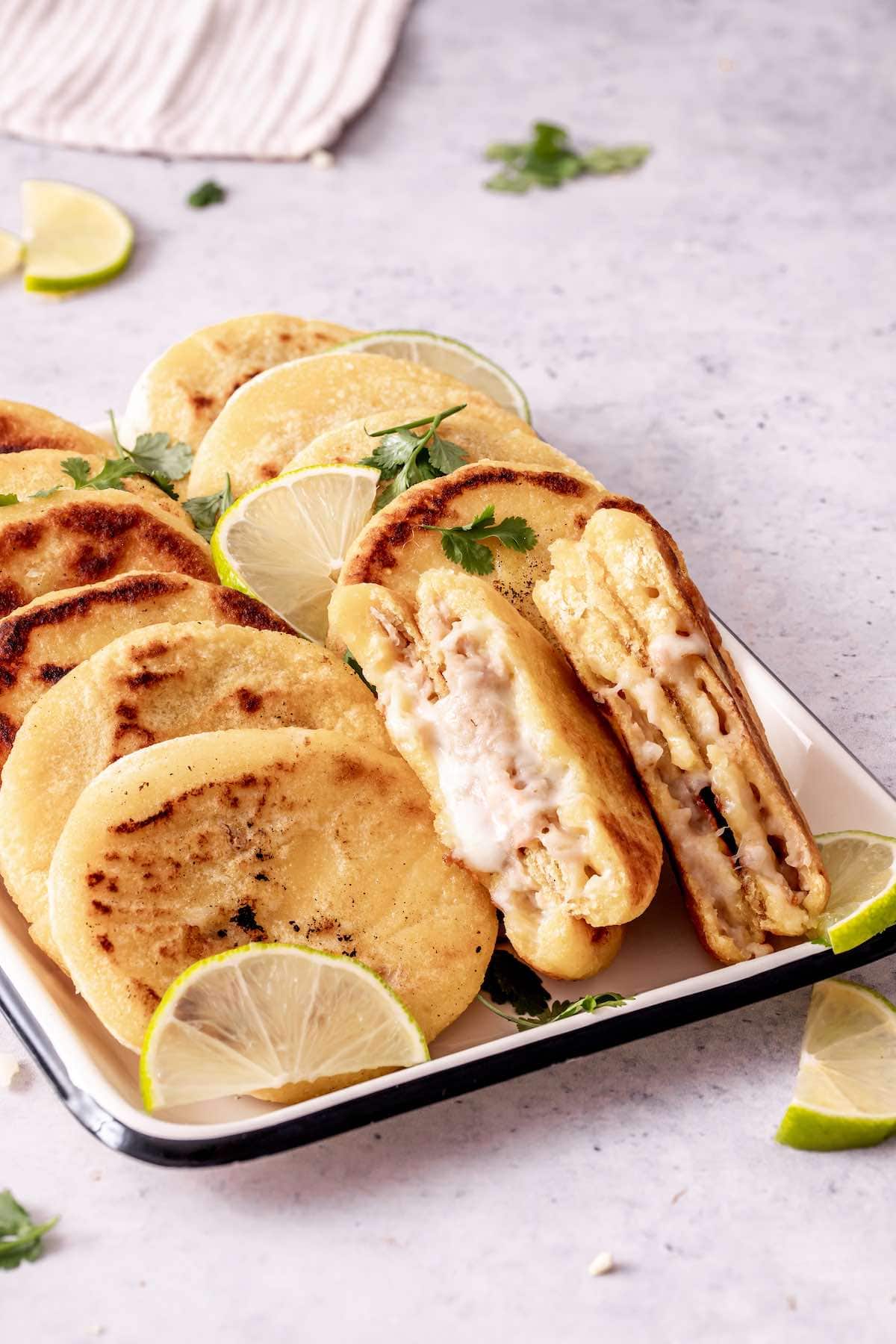 pupusas stuffed with beans and cheese in a white tray.