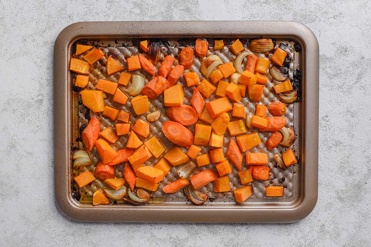 roasted carrots, onion, and buttercup squash on baking sheet.