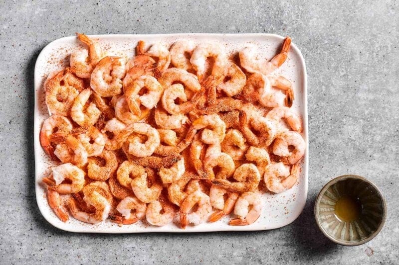 seasoned shrimp on a white tray.