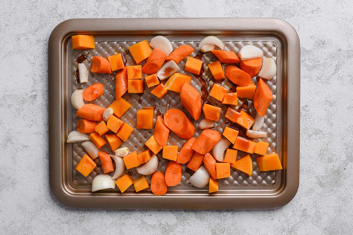 seasoned carrots, onion, and buttercup squash on baking sheet.