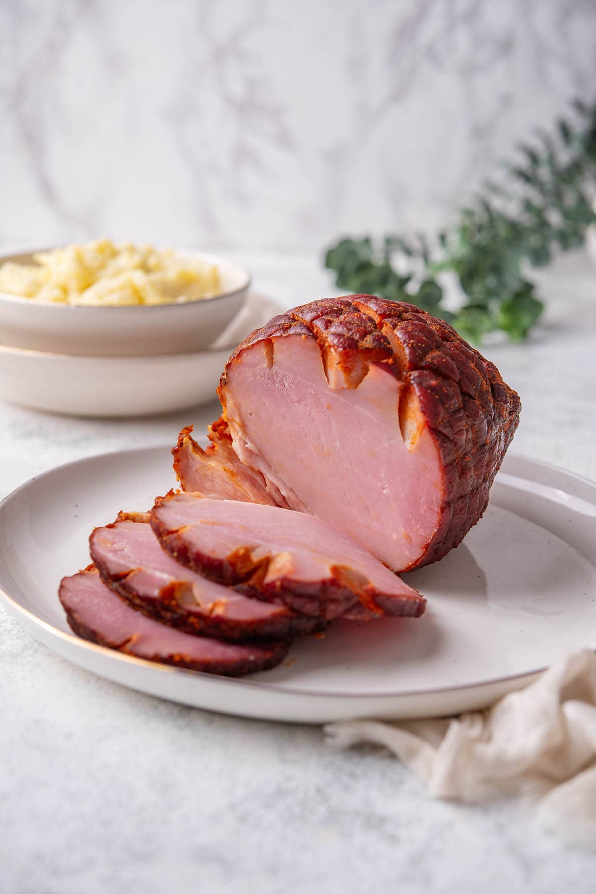 smoked ham sliced on a white plate.