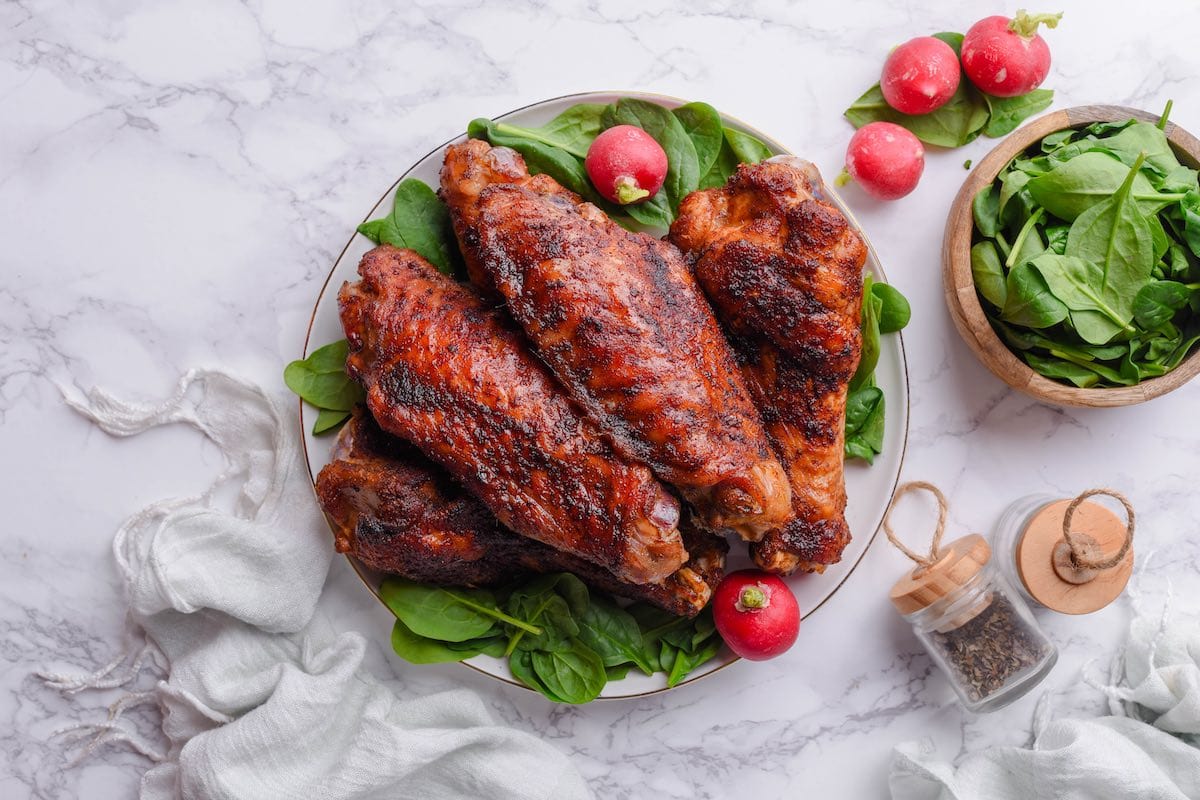 cooked smoked turkey wings with greens and tomatoes.