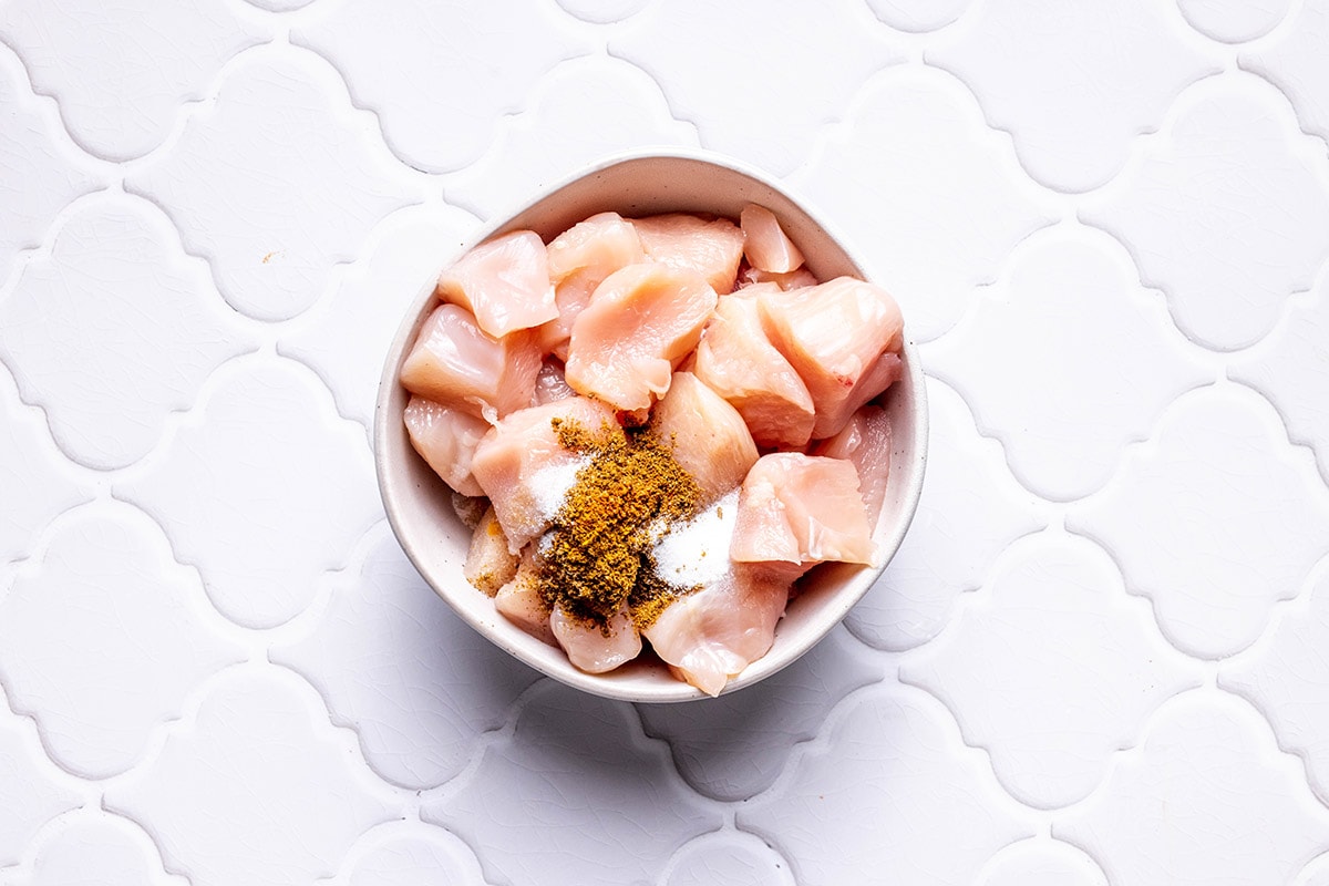 raw chicken breast pieces and seasonings.