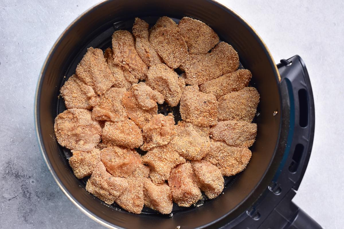 breaded raw chicken pieces in air fryer.