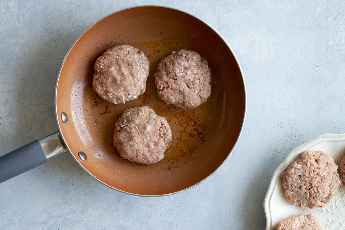 raw turkey sausage in skillet.