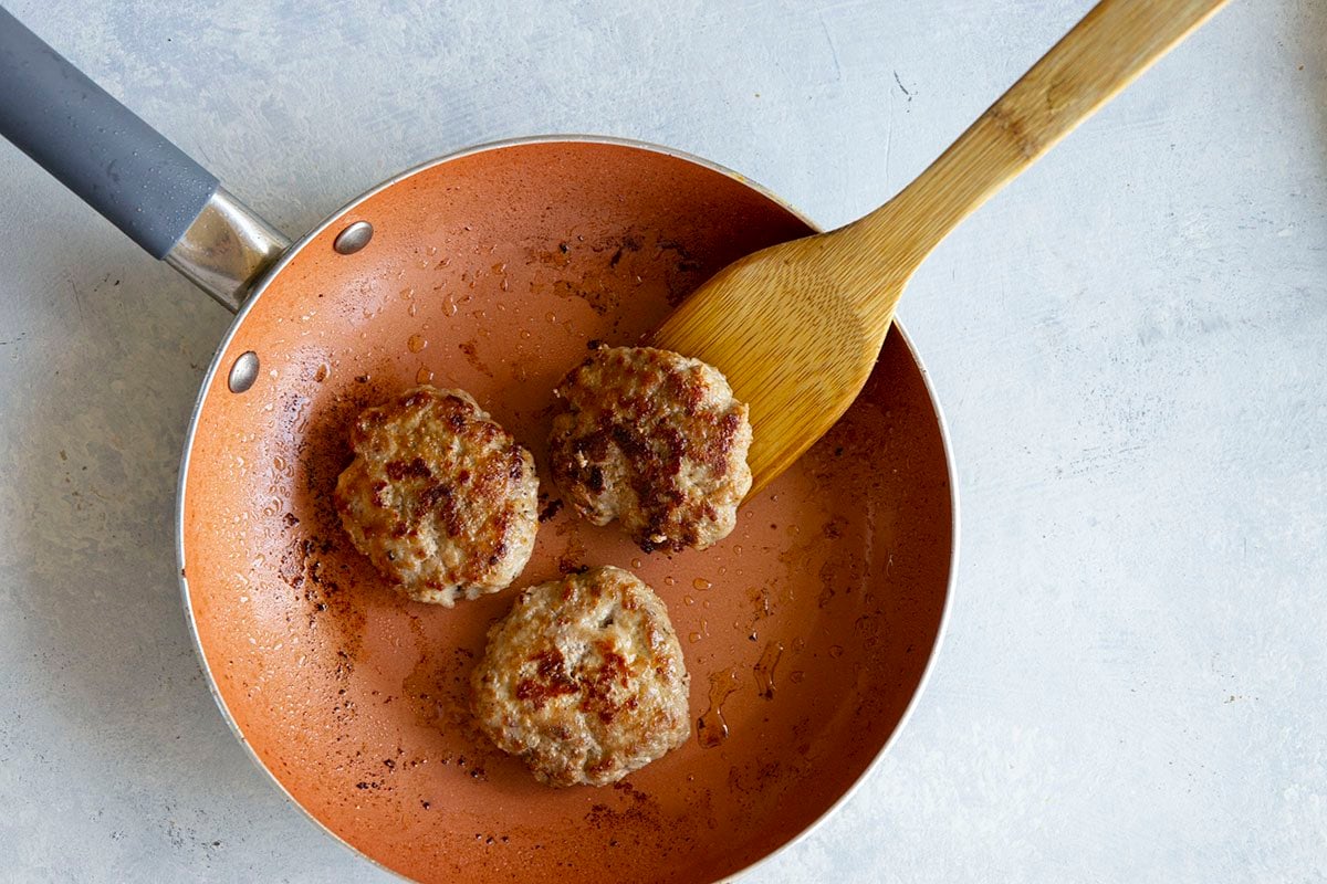 fried turkey sausage patties in skillet.