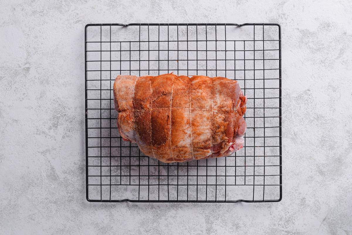 seasoned lamb on a smoking rack.