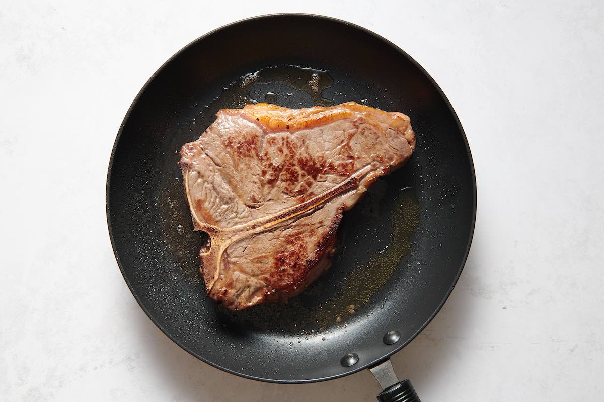 searing porterhouse steak.