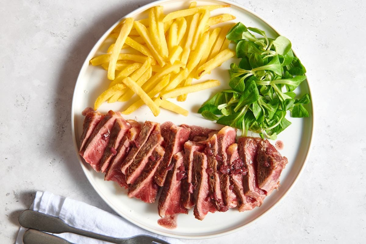 porterhouse steak with fries and salad.