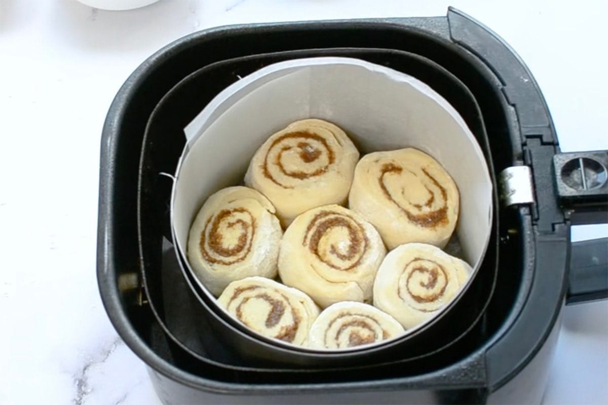 unbaked cinnamon rolls in the air fryer basket.