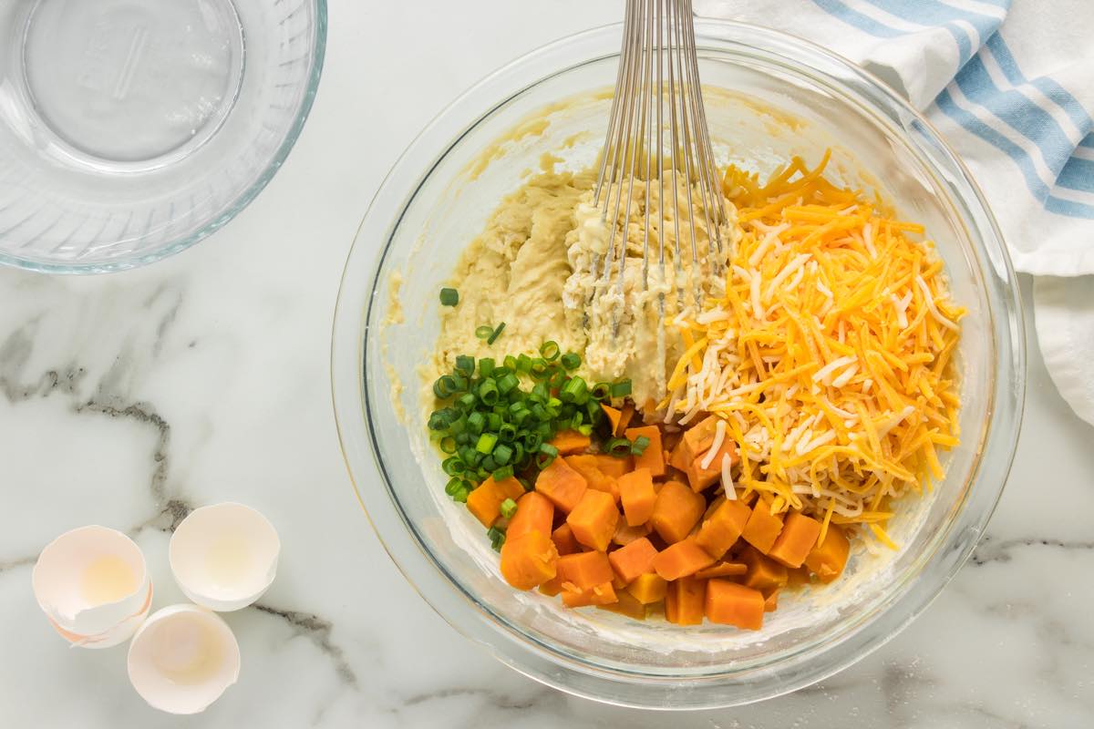 sweet potato, shredded cheese, and pancake batter in a bowl.