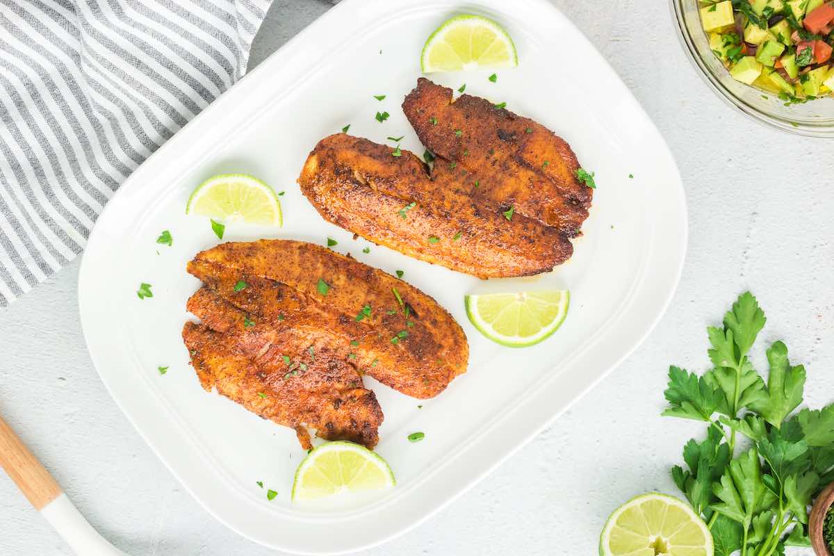 blackened tilapia fillets on a plate. 