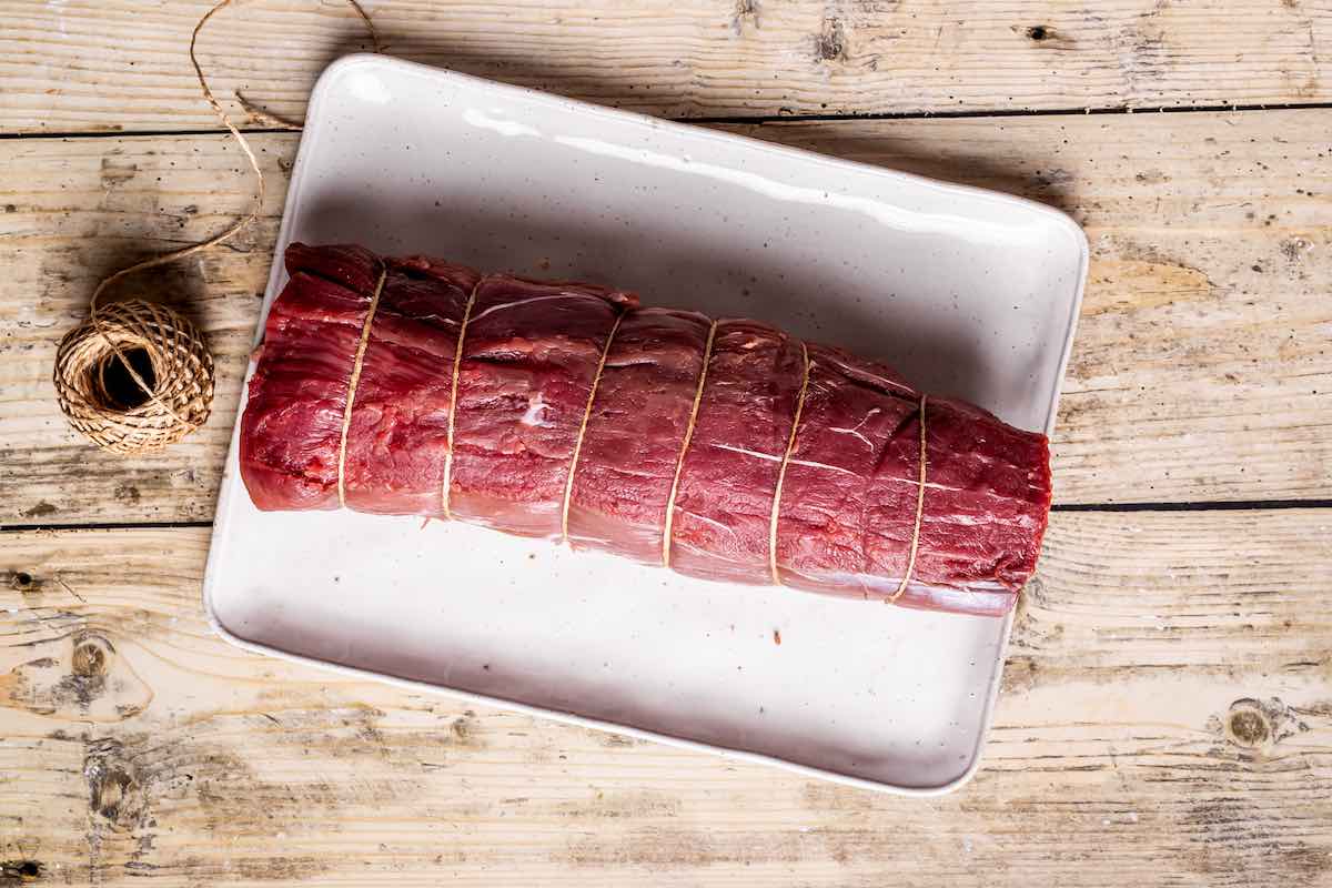 raw beef tenderloin tied with sinew.