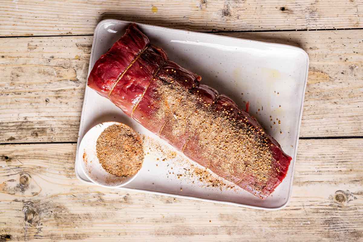 seasoned raw beef tenderloin on a wire rack.