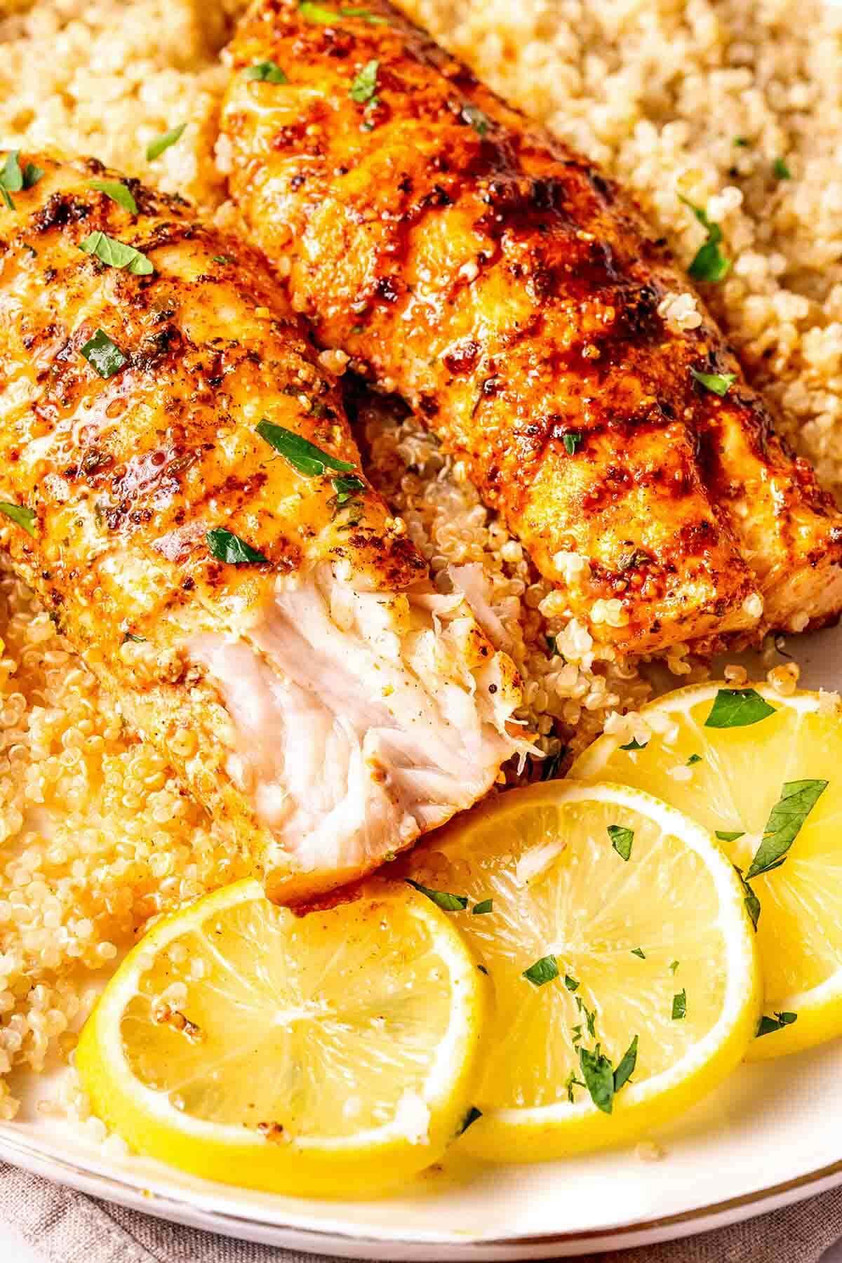 seared orange roughy on a plate with couscous and lemon.