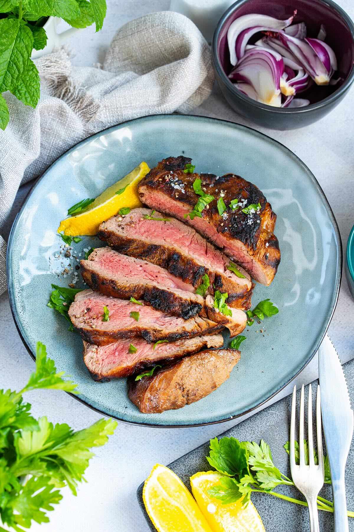 sliced denver steak on a plate.