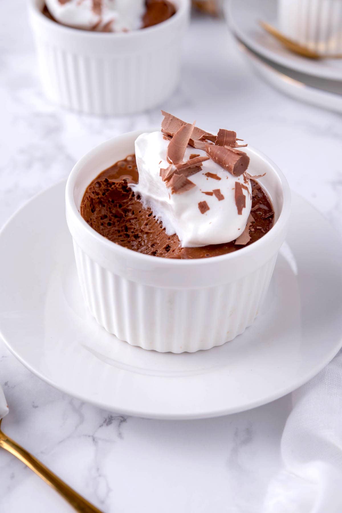 chocolate pot de creme with whipped cream on top.