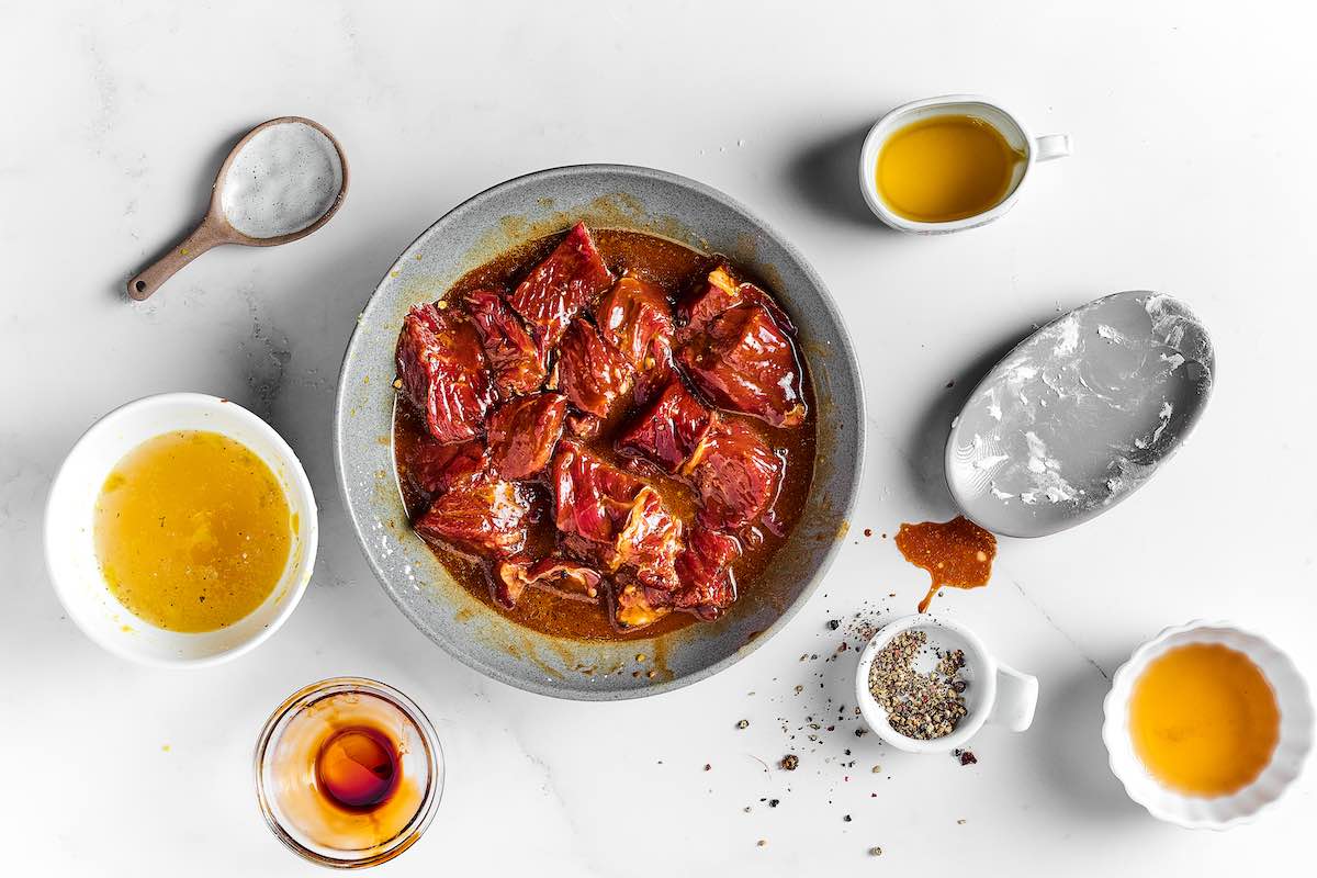 steak marinating in a bowl.