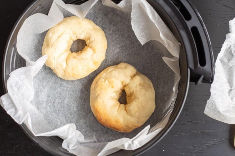 uncooked donuts in air fryer basket.