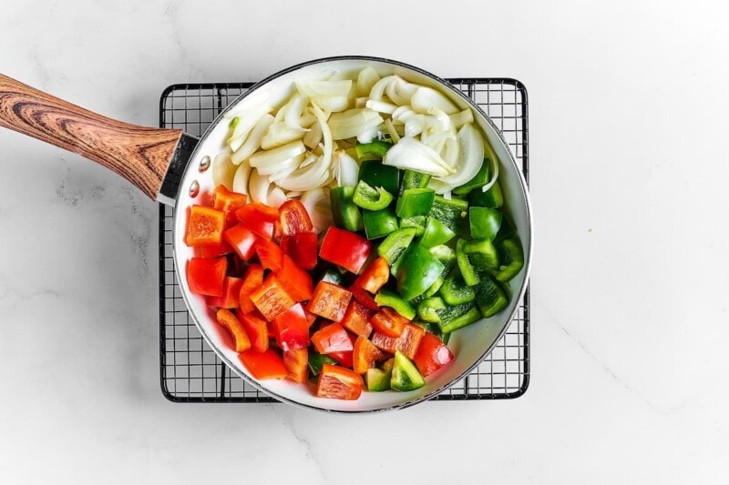 red and green bell peppers and onions in a skillet.