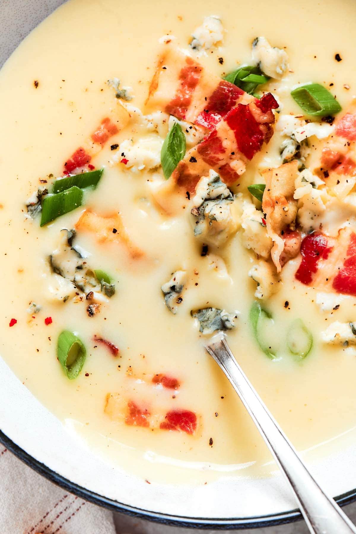 creamy potato soup with chopped bacon and green onions on top.