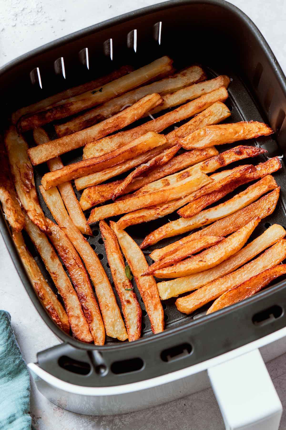 air fryer french fries in the air fryer basket.