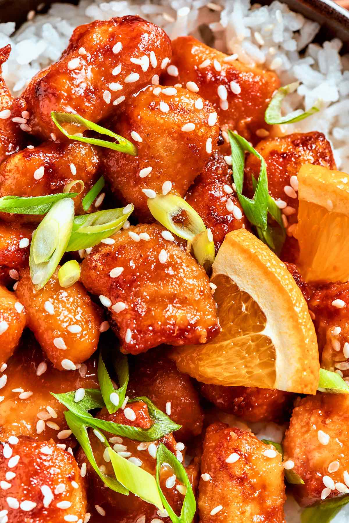 air fryer orange chicken with green onions on top.