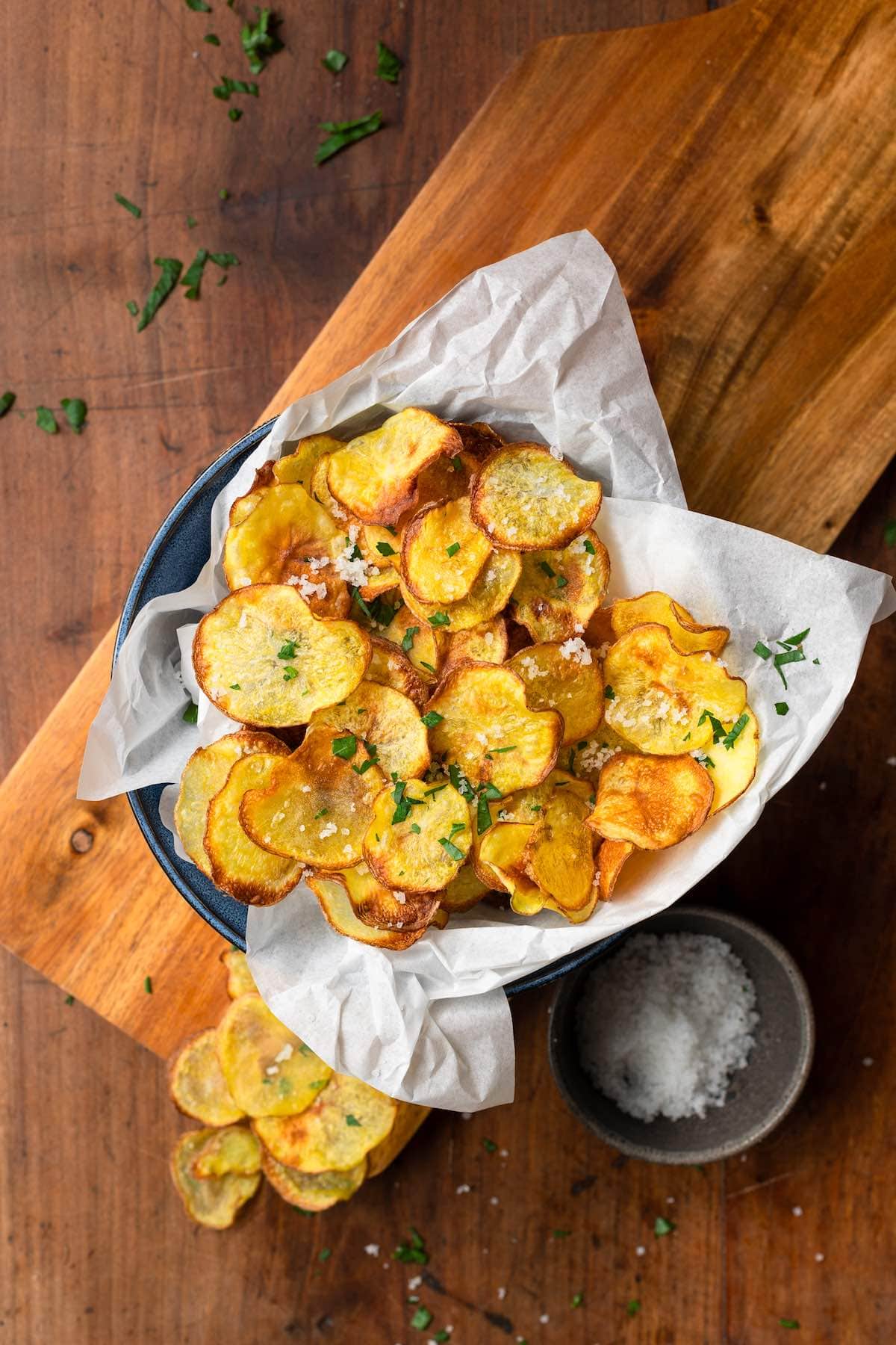 air fryer potato chips with sea salt and chopped parsley on top.